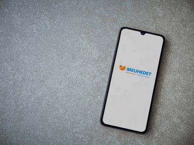 Lod, Israel - 8 Temmuz 2020: Meuhedet Sağlık Hizmetleri uygulama ekranı seramik taş zemin üzerinde siyah bir cep telefonunun logosu var. Üst görünüm düzlüğü kopyalama alanı ile yatıyordu.