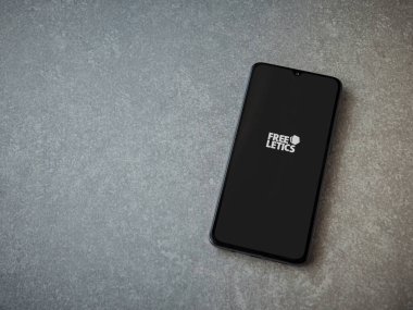 Lod, Israel - 8 Temmuz 2020: Freeletics Eğitim Koçu uygulama ekranı seramik taş zemin üzerinde siyah bir cep telefonunun logosu var. Üst görünüm düzlüğü kopyalama alanı ile yatıyordu.