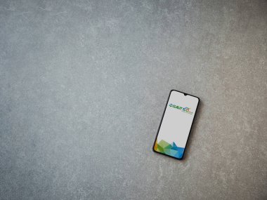 Lod, Israel - 8 Temmuz 2020: Clalit Sağlık Hizmetleri uygulama ekranı seramik taş zemin üzerinde siyah bir cep telefonunun logosu var. Üst görünüm düzlüğü kopyalama alanı ile yatıyordu.