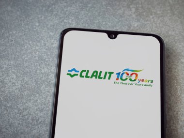 Lod, Israel - 8 Temmuz 2020: Clalit Sağlık Hizmetleri uygulama ekranı seramik taş zemin üzerinde siyah bir cep telefonunun logosu var. Üst görünüm düzlüğü kopyalama alanı ile yatıyordu.