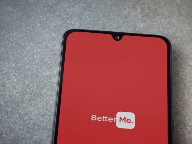 Lod, Israel - 8 Temmuz 2020: BetterMe uygulama ekranı seramik taş zemin üzerinde siyah bir cep telefonunun logosu var. Üst görünüm düzlüğü kopyalama alanı ile yatıyordu.