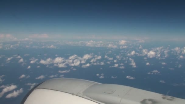 Luchtfoto van wolken boven de zee met blauwe hemel van binnen een vliegtuig — Stockvideo