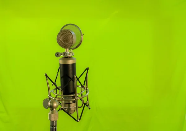 Mikrofon kondensor vokal dengan layar angin diisolasi pada latar belakang hijau — Stok Foto