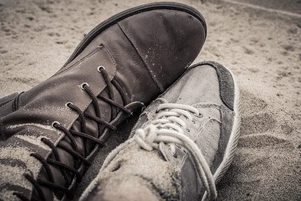 Ayakkabı erkek ve kadın yan yana kumun üzerinde yalan — Stok fotoğraf