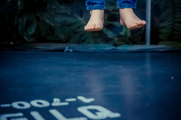 Piernas flotando en el aire después de saltar sobre el trampolín — Foto de Stock