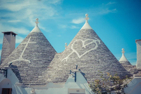 Крупный план конической крыши домов Трулли с раскрашенными символами — стоковое фото