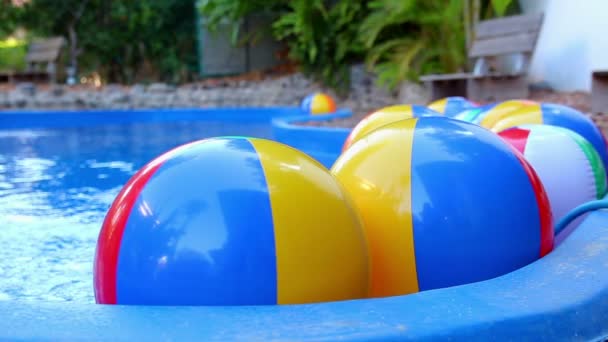 Boules de plage colorées flottant dans la piscine — Video