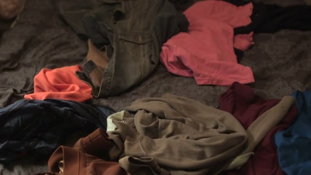 Roupas jogadas em uma pilha de roupas na cama — Vídeo de Stock