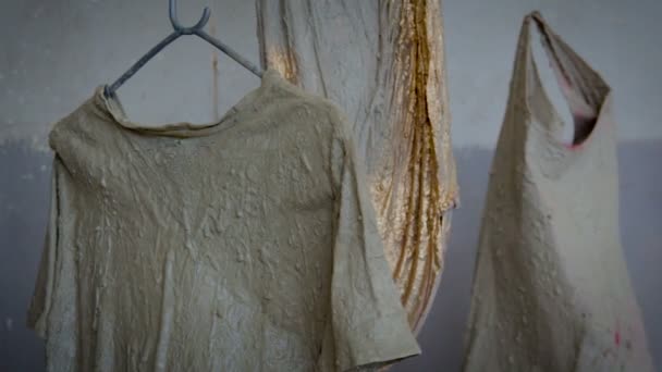 Clothes coated with concrete are hanging in the air — Stock Video