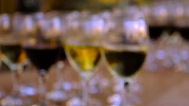 Vasos de vino tinto y blanco sobre una mesa de madera — Vídeos de Stock