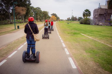 Group of people traveling on Segway in the park clipart