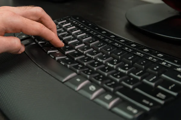 Hombre escribiendo en un teclado con letras en hebreo e inglés —  Fotos de Stock