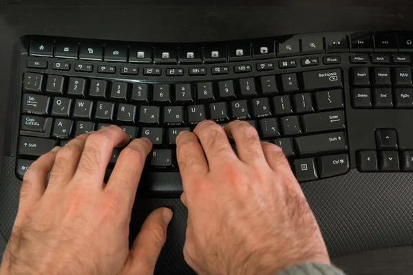 Hombre escribiendo en un teclado con letras en hebreo e inglés —  Fotos de Stock