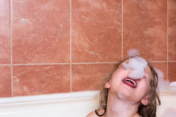 Маленькая девочка купается в ванне с пеной — стоковое фото