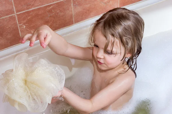 Маленькая девочка принимает ванну с пеной — стоковое фото