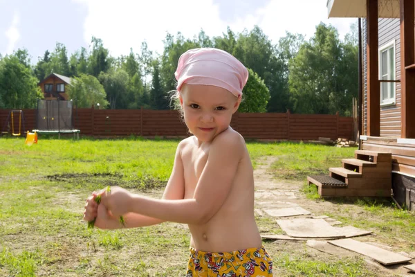 Meisje tranen een plukje gras in handen — Stockfoto