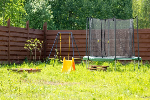 Children playground with trampoline and swings — Stock Photo, Image