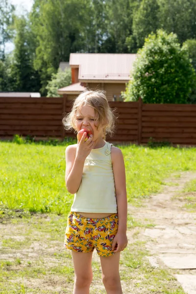 Meisje eet rode appel buiten — Stockfoto