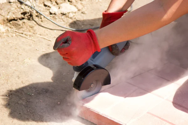 Человек вырезал плиты из красного бетона — стоковое фото