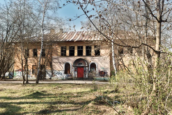 Εγκαταλελειμμένο κτίριο με γκράφιτι στον κήπο άνοιξη — Φωτογραφία Αρχείου