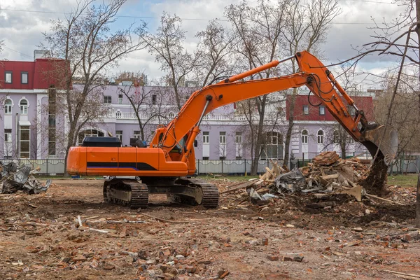 Koparka usuwa odpady budowlane po rozbiórki budynku — Zdjęcie stockowe