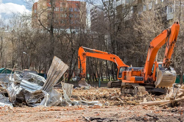 Экскаватор удаляет строительные отходы после сноса зданий — стоковое фото