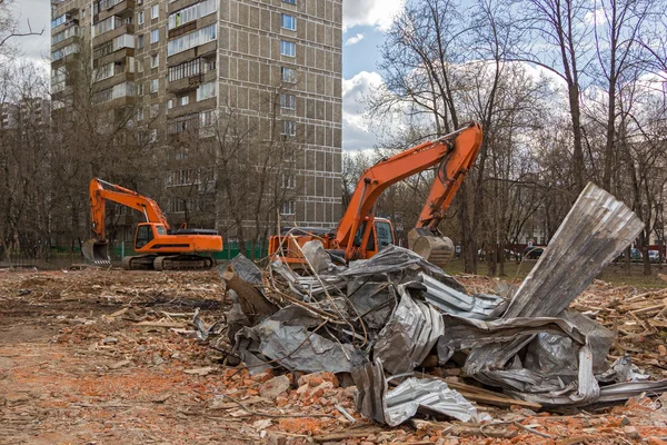 Экскаватор удаляет строительные отходы после сноса зданий — стоковое фото