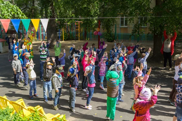 Νηπιαγωγό διασκεδάσει τα παιδιά στα κοστούμια του buffoons στο το — Φωτογραφία Αρχείου