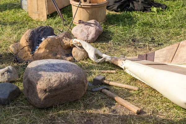 Fragua antigua arcilla, pieles, martillo y otras herramientas — Foto de