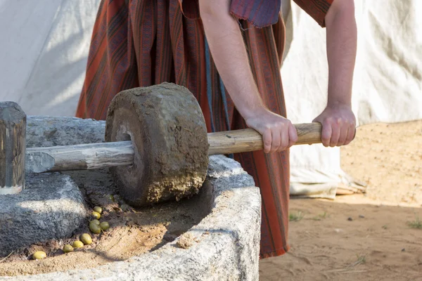 Man works at ancient Roman press for olive oil — Stock Photo, Image