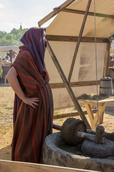 Man beside ancient Roman press for olive oil — Stock Photo, Image