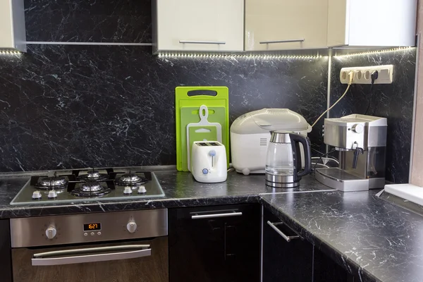 Kitchen appliances on black worktop with LED backlight — Stock Photo, Image