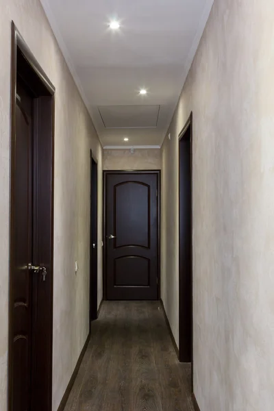 Узкий коридор с четырьмя коричневыми дверями — стоковое фото
