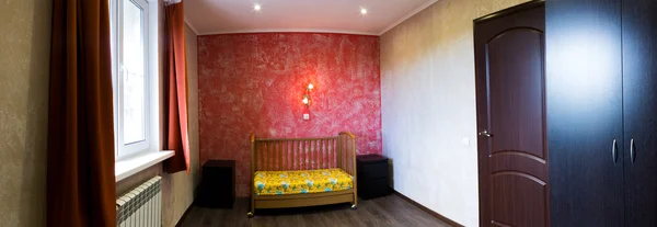 Cot in a bedroom at the red wall — Stock Photo, Image