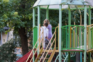 üç çocuk slayttan aşağı taşımak hazırlanıyor