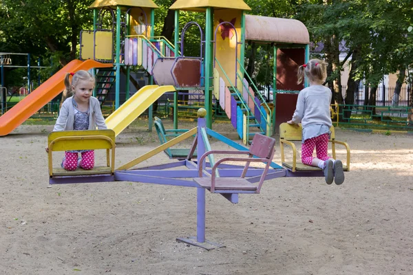 Twee kopieën van een meisje dwarrelen op carrousel — Stockfoto