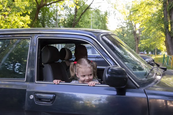 Malá holčička vypadá z dědeček automobil — Stock fotografie