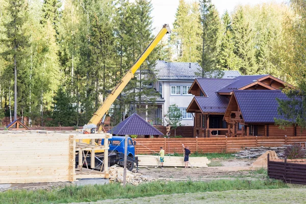 Jeřáb zvedá prkna postavit dům — Stock fotografie