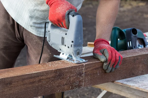 Man händerna skärande balk med sticksåg — Stockfoto