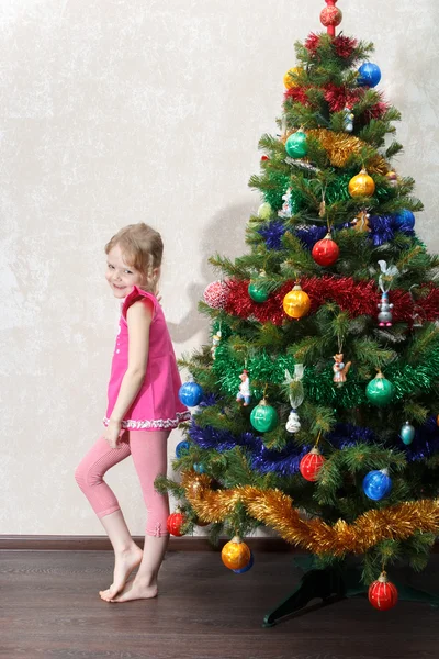 Verward meisje in de buurt van de kerstboom Stockafbeelding