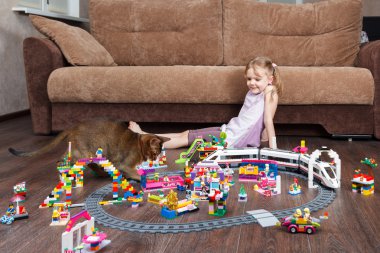 Lego oynarken bir kedi ile küçük kız