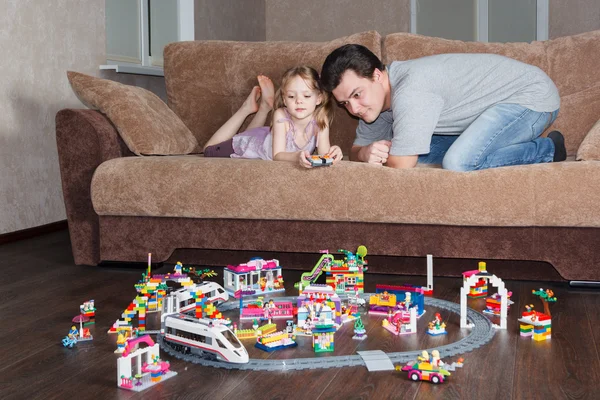 Девочка с папой играют в Лего на диване — стоковое фото