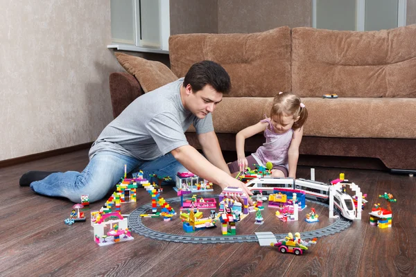 Девочка с папой играют в Лего на диване — стоковое фото