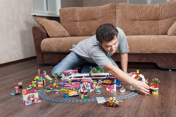Lego yerleşik bir kasaba ile oynayan adam