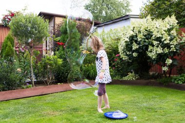 güzel bahçede sabun köpüğü ile oynayan kız