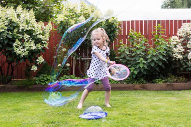 güzel bahçede sabun köpüğü ile oynayan kız