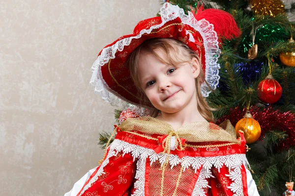 Little girl in carnival costume near Christmas tree — Stock Photo, Image