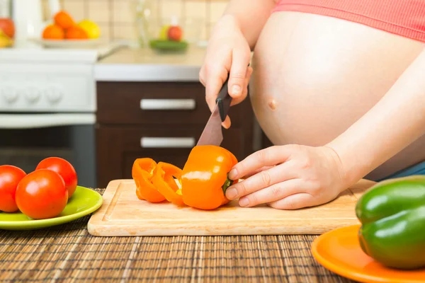 Pregnant woman preparing a healthy meal in the kitchen — Stock Photo, Image