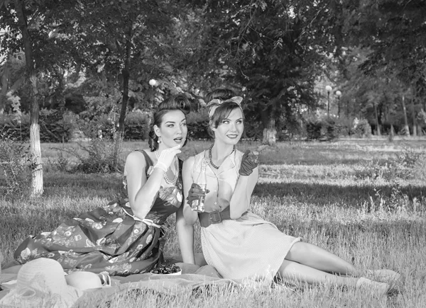 Beautiful girl sitting on the grass in retro style — Stock Photo, Image