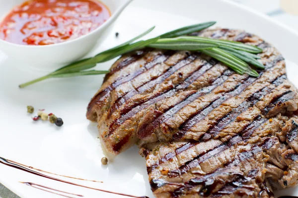 Deliziosa bistecca fritta con salsa e spezie su un piatto bianco — Foto Stock